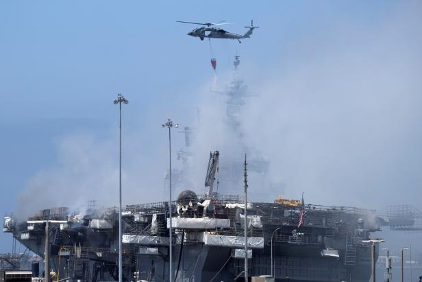 U.S. Navy helicopters continue fighting a fire on the amphibious assault ship USS Bonhomme Richard at Naval Base San Diego