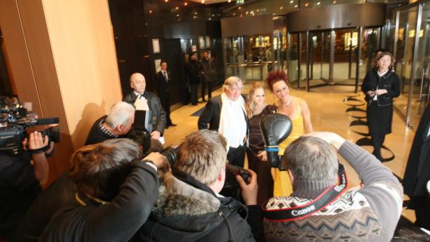 Eine Gruppe von Menschen posiert für Fotografen vor einem Gebäude.