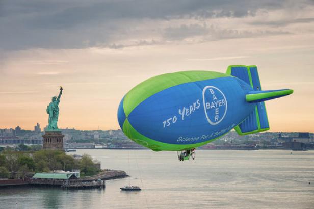 Ein Bayer-Luftschiff fliegt vor der Freiheitsstatue in New York.