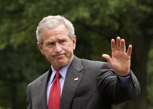 George W. Bush winkt mit erhobener Hand.