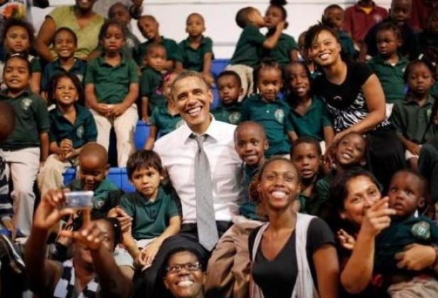 Barack Obama posiert mit einer Gruppe von Schulkindern für ein Foto.