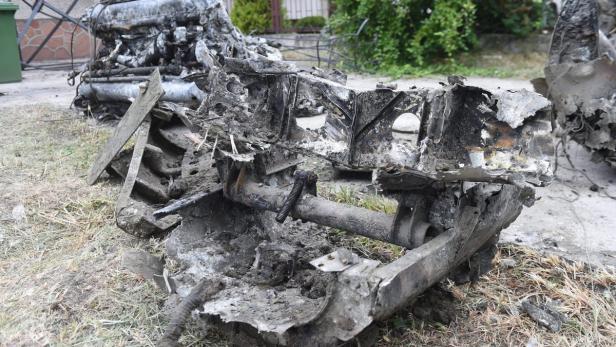Die Überreste eines zerstörten Fahrzeugs liegen auf dem Boden.