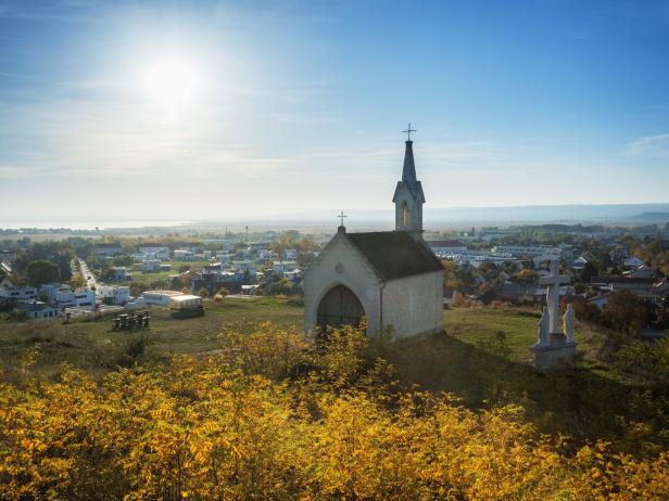 Eine kleine Kapelle auf einem Hügel mit Blick auf eine Stadt.