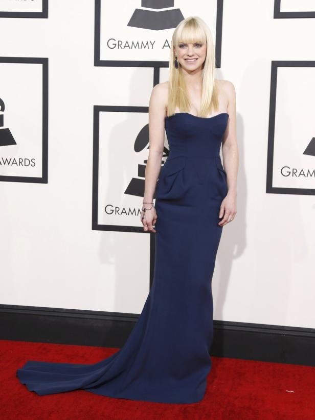 Anna Faris in einem trägerlosen, marineblauen Kleid auf dem roten Teppich.