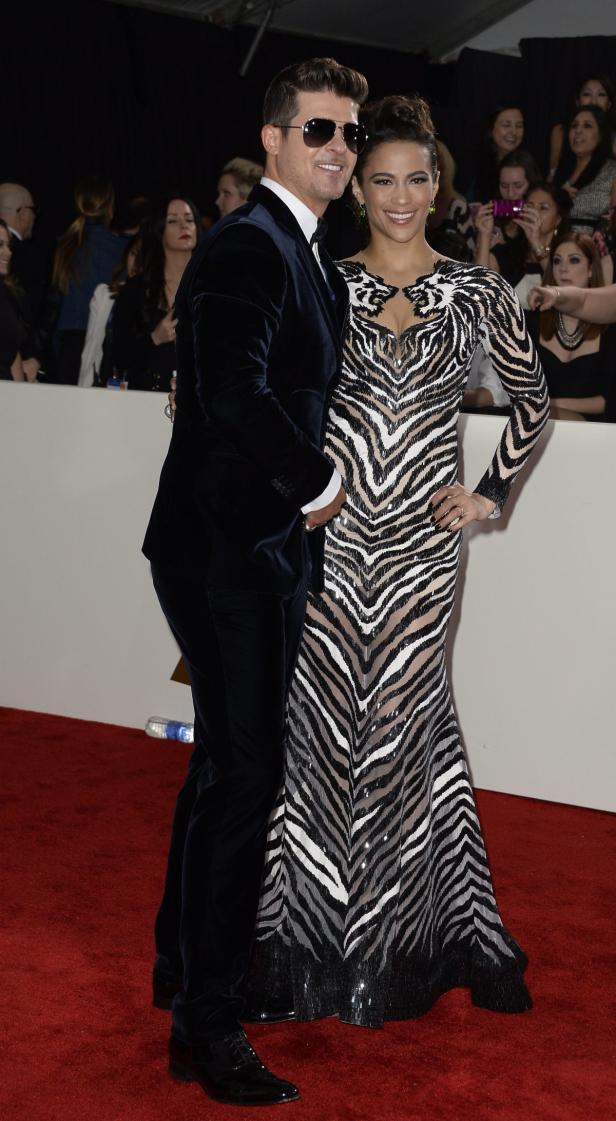 Robin Thicke und Paula Patton posieren auf einem roten Teppich.