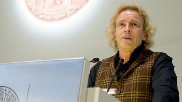 Ein Mann mit blonden Haaren spricht an einem Rednerpult.