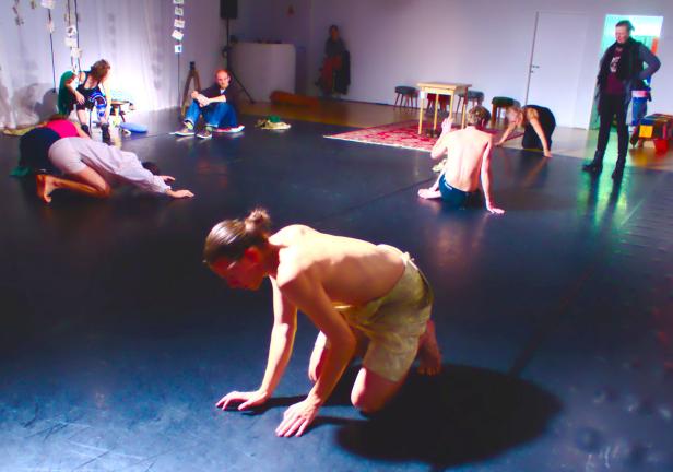 Mehrere Personen bewegen sich auf einer Bühne während einer Performance.