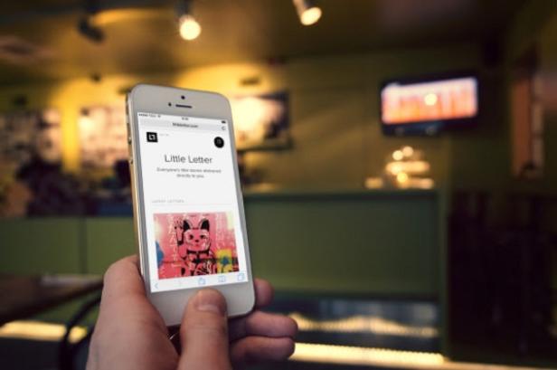 Eine Person hält ein iPhone mit der Webseite „Little Letter“ in der Hand.