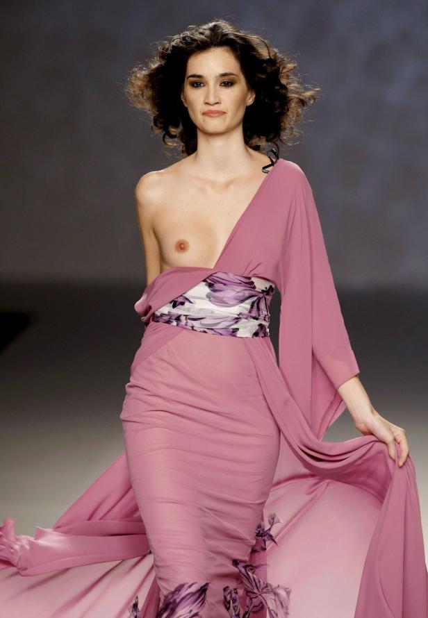 Eine Frau in einem rosa Kleid mit Blumenmuster auf einem Laufsteg.