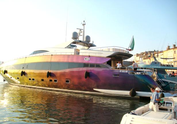 Eine große, farbenfrohe Yacht liegt im Hafen.