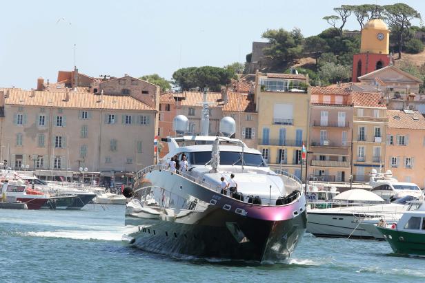 Eine große Yacht fährt in den Hafen von Saint-Tropez ein.