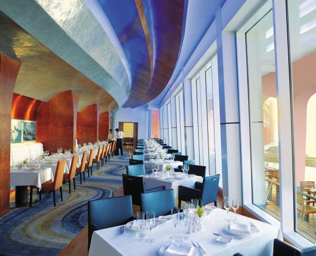 Ein elegantes Restaurant mit gedeckten Tischen und großen Fenstern mit Ausblick.