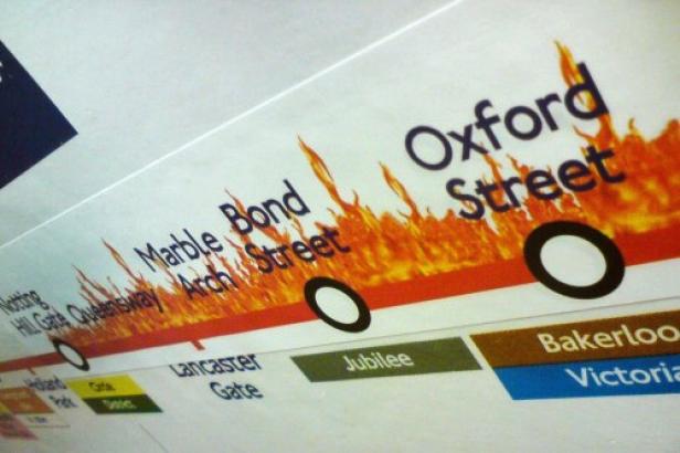 Ein Ausschnitt aus einer Londoner U-Bahnkarte mit den Stationen Marble Arch, Bond Street und Oxford Street, die von Flammen umgeben sind.