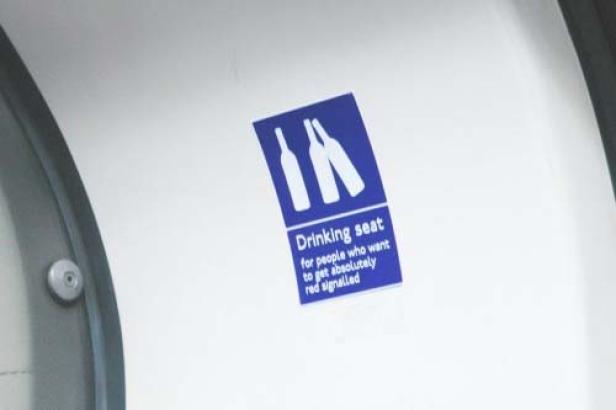 Ein blaues Schild mit der Aufschrift „Drinking seat for people who want to get absolutely red signalled“.