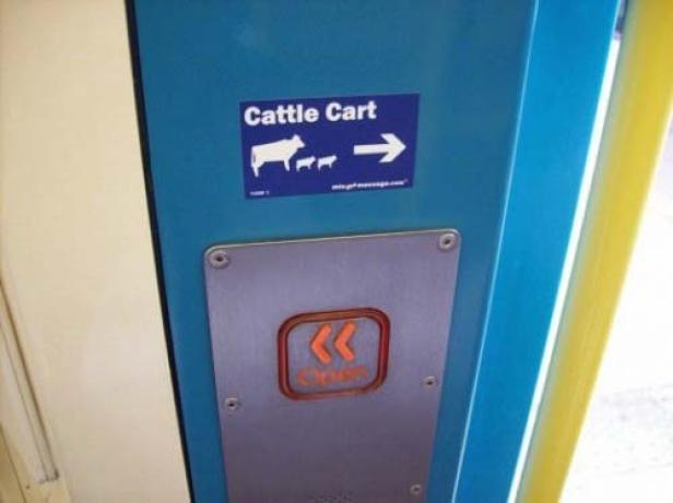 Auf einem blauen Bedienfeld befindet sich ein Aufkleber mit der Aufschrift „Cattle Cart“ und ein Knopf zum Öffnen.