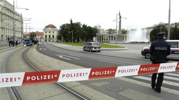Ein abgesperrter Bereich in Wien mit einem Polizisten und einem Polizeiauto im Hintergrund.