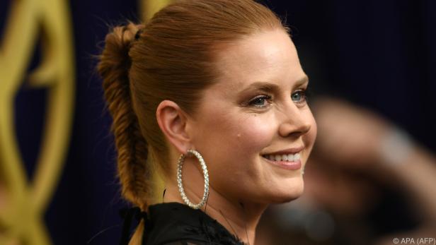 Nahaufnahme von Amy Adams mit hochgesteckten Haaren und Ohrringen.