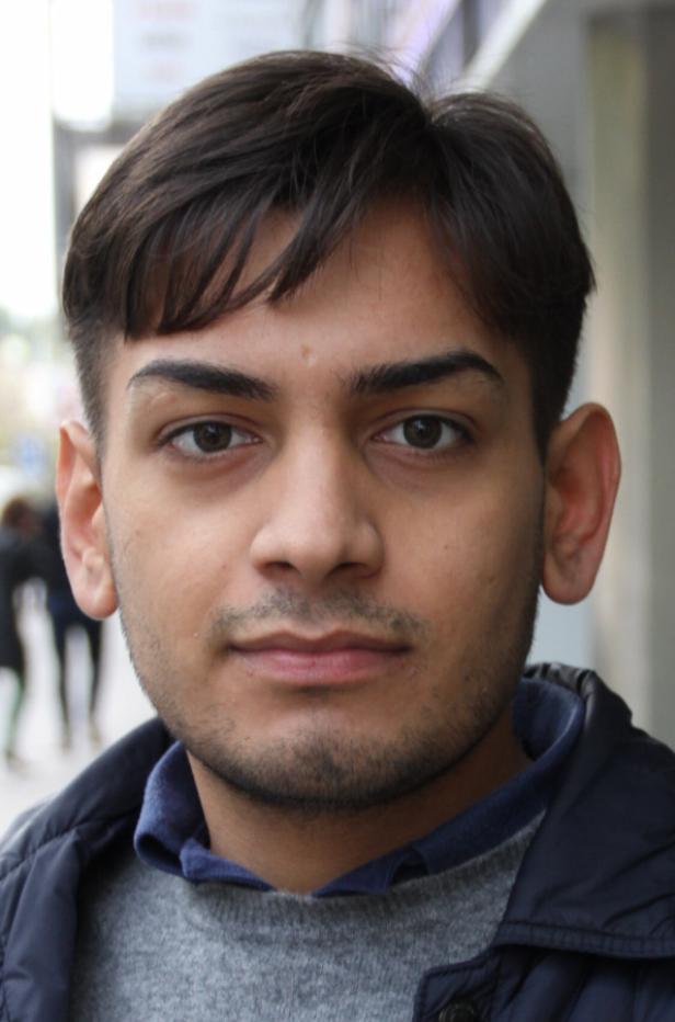 Ein junger Mann mit dunklen Haaren und braunen Augen blickt in die Kamera.