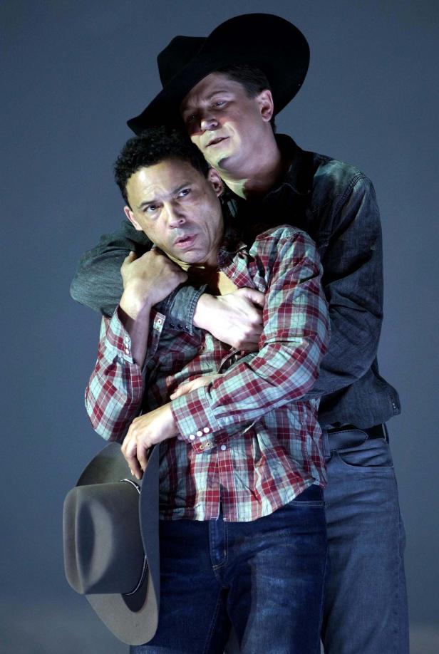 Zwei Männer umarmen sich, einer trägt einen Cowboyhut.