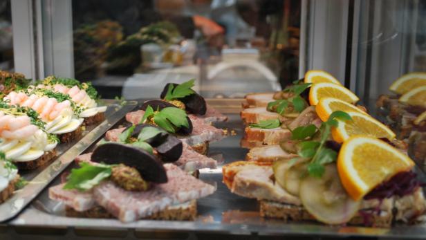 Verschiedene Sorten belegte Brote in einer Auslage, darunter mit Krabben und mit Fleisch belegte Brote.