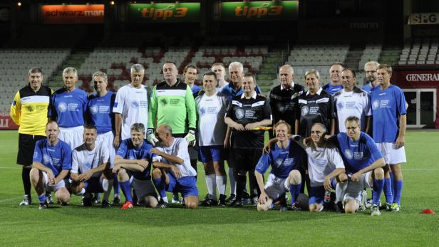 Eine Gruppe von Männern posiert auf einem Fußballfeld für ein Mannschaftsfoto.