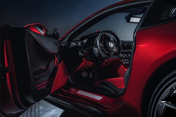 Der Innenraum eines roten Touring Aero 3 mit offenstehender Tür.