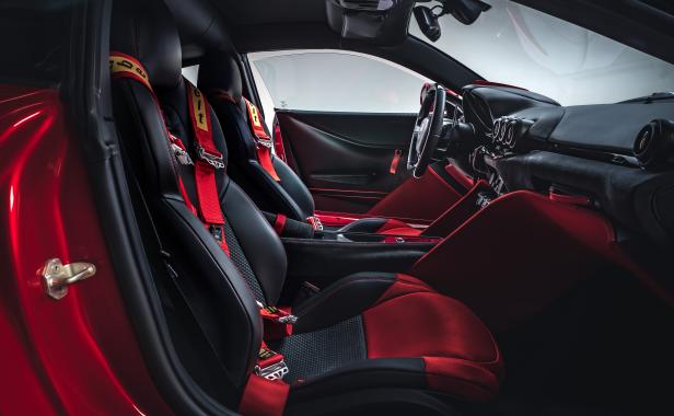 Das Interieur eines Sportwagens mit roten Sicherheitsgurten und Sitzen.