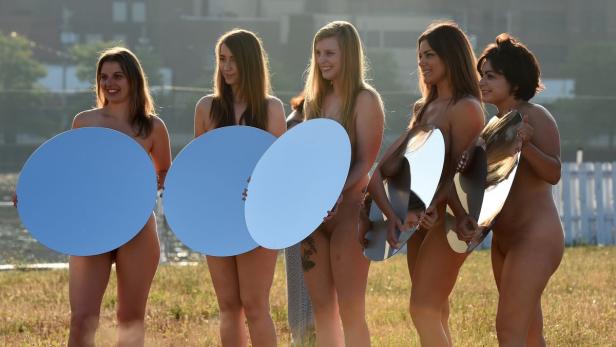 Fünf Frauen stehen im Freien und halten Spiegel vor ihren Körpern.