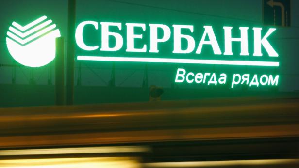 An illuminated sign with the company logo of Sberb