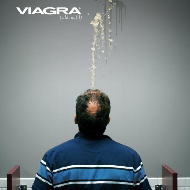 Ein Mann steht vor einer Wand, über seinem Kopf ist ein Viagra-Logo und eine Flüssigkeitsspritzer zu sehen.