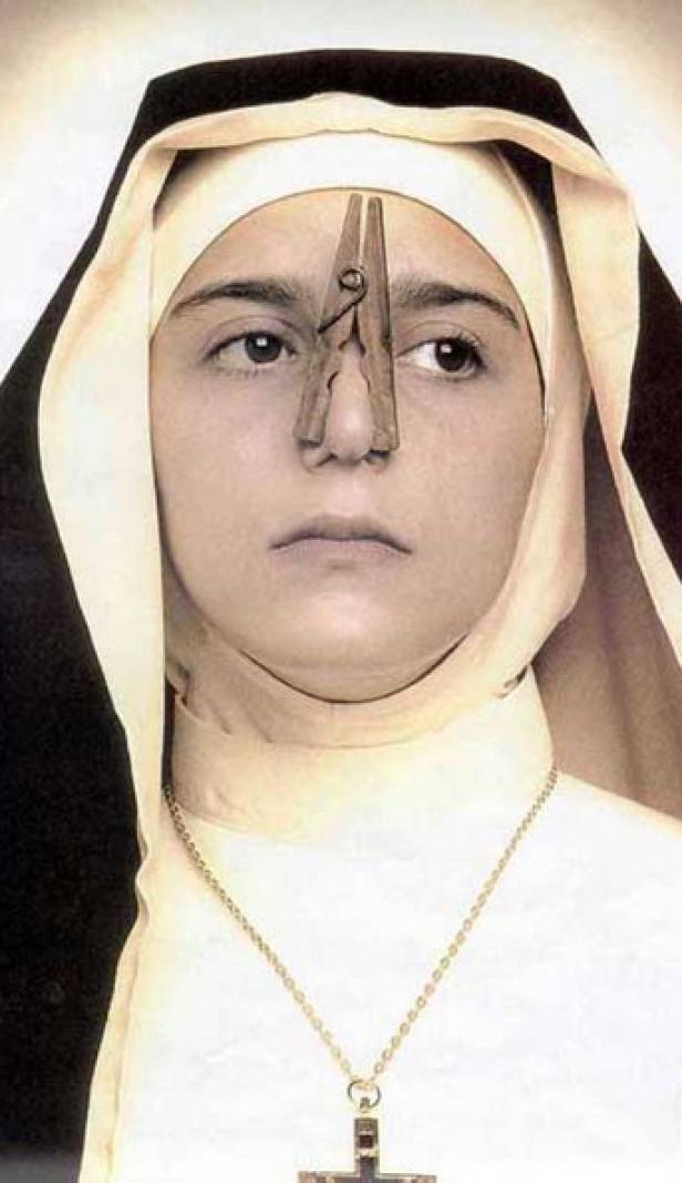 Eine Nonne mit einer Wäscheklammer auf der Nase.