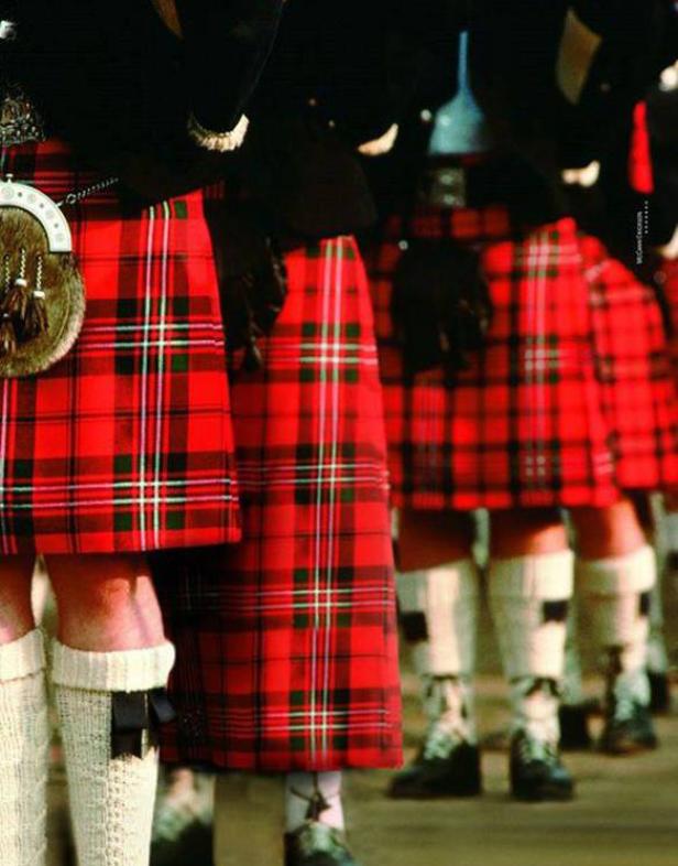 Eine Reihe von Männern in traditionellen schottischen Kilts und Kniestrümpfen.