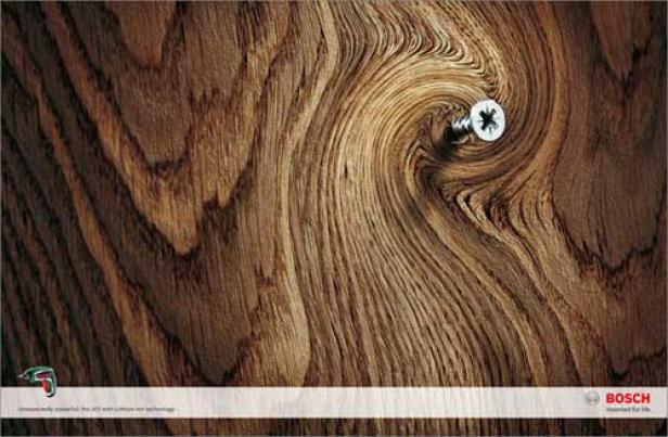 Eine Schraube wurde in ein Stück Holz mit auffälliger Maserung gedreht.