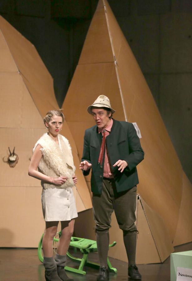 Zwei Schauspieler in Kostümen stehen auf einer Bühne vor einer Kulisse aus Karton.