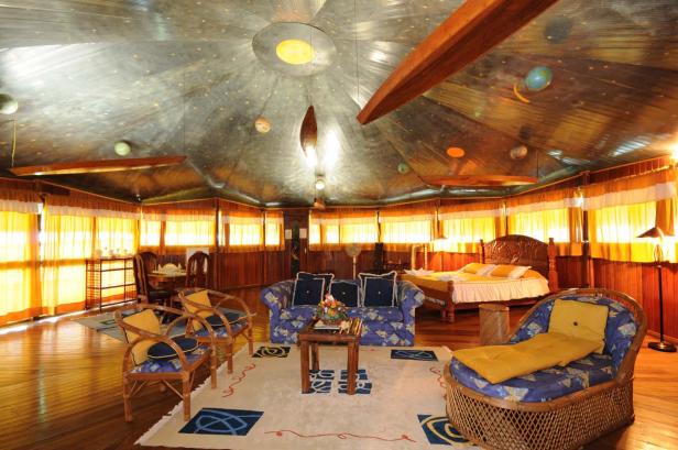 Ein Innenraum mit einem Bett, einer Couch und einem sternenübersäten Himmel an der Decke.