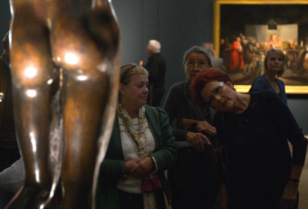 Besucherinnen betrachten eine Bronzeskulptur in einem Museum.