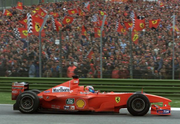 FILE PHOTO: Germany's Michael Schumacher drives past Ferrari fans en route to a narrow victory over Mika Hakkinen in the San Marino Grand Prix.