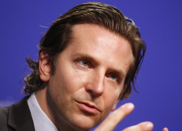 Porträt von Bradley Cooper vor einem blauen Hintergrund.