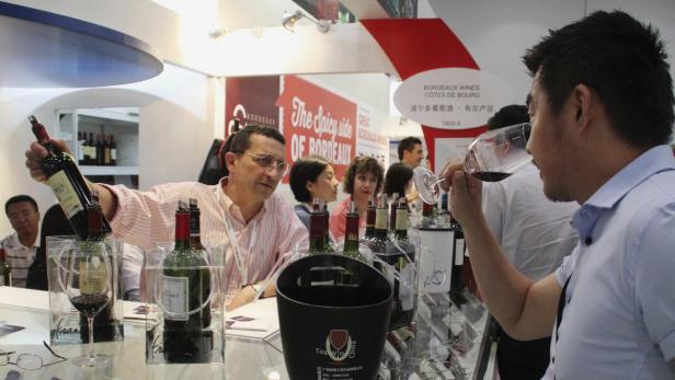 Auf einer Weinmesse probieren Menschen Bordeaux-Weine.