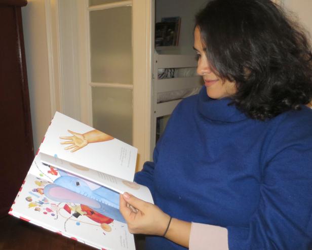 Autorin blättert ihr Bilderbuch fürs Foto durch