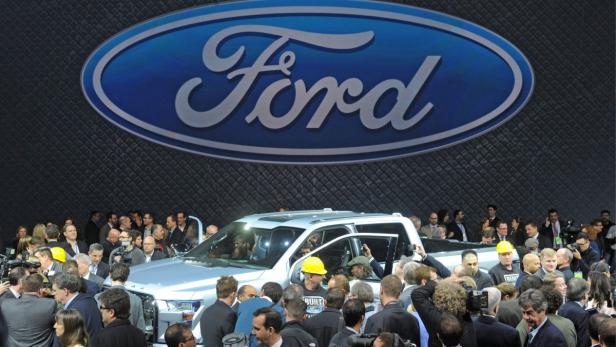 Ein silberner Ford-Truck wird auf einer Automobilmesse von einer Menschenmenge umringt.