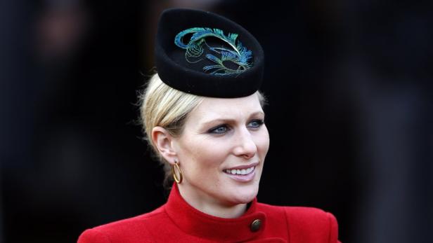 Zara Tindall mit einem eleganten schwarzen Hut mit blaugrünen Federn.