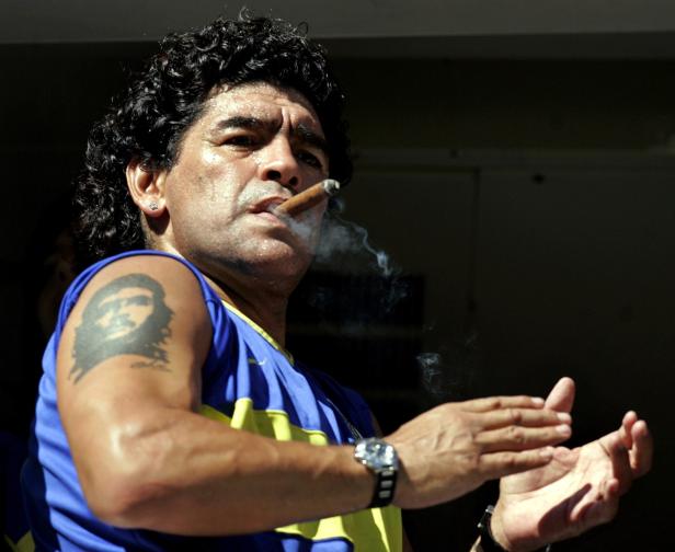 FILE PHOTO: Former Argentine soccer star Maradona smokes a cigar before the start of a soccer match in Buenos Aires