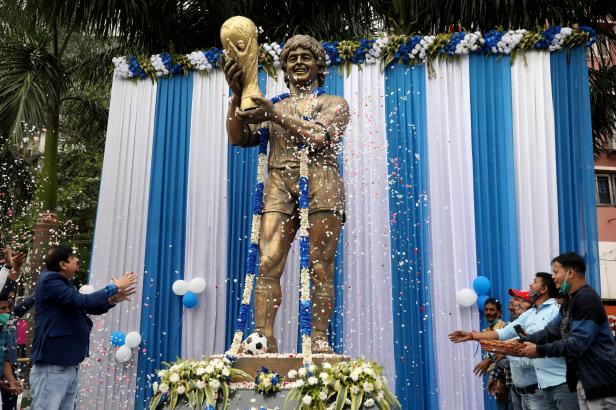 People shower petals on a statue of Argentine soccer great Diego Maradona during a prayer meeting to pay tribute to Maradona, in Kolkata