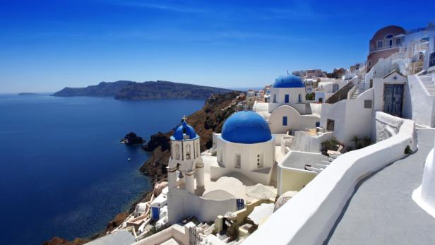 Blick auf die weiß getünchten Häuser und blauen Kuppeln von Santorin, Griechenland.