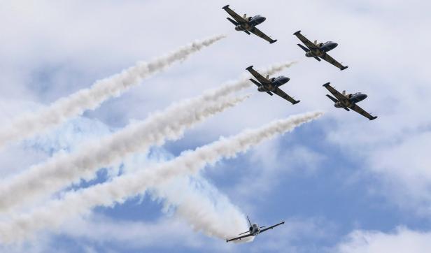 Fünf Flugzeuge ziehen Rauchstreifen in den Himmel.