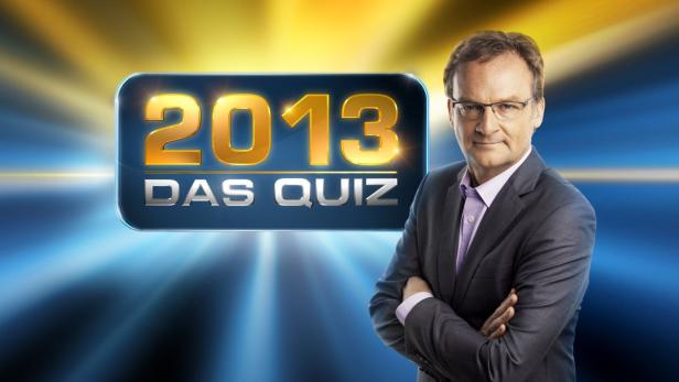 Ein Mann mit Brille und Anzug vor dem Logo der Quizsendung „2013 – Das Quiz“.