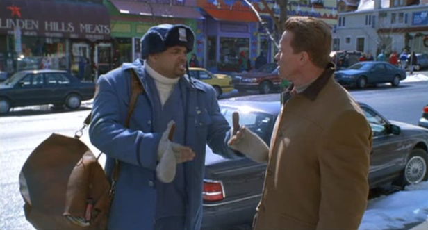 Ein Postbote und ein Mann unterhalten sich auf einer verschneiten Straße.