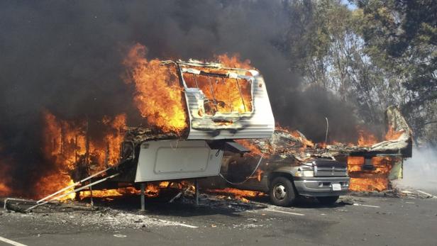 Ein Wohnwagen steht in Flammen, nur noch das Fahrgestell und Teile der Karosserie sind erkennbar.