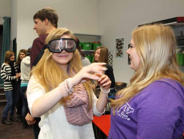 Eine junge Frau trägt eine Schutzbrille und scheint an einem Spiel teilzunehmen.